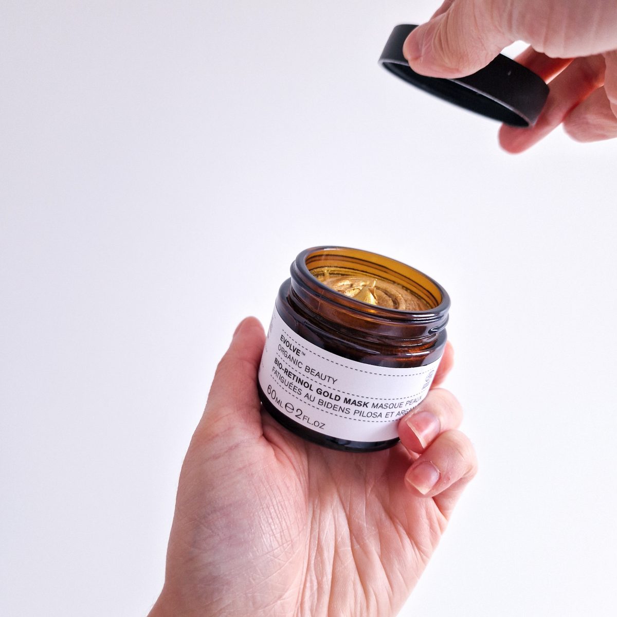 Masque éclat à base de bio-retinol et huile d'argan de la marque Evolve Beauty. Pot ouvert, texture crème, couleur dorée.
